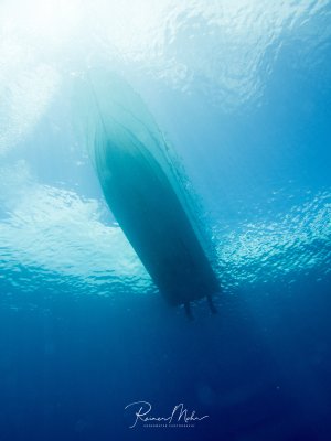 Ein Tauchboot von unten gegen die Sonne fotografiert