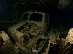 Innenraum eines Lastwagens im Wrack der SS Thistlegorm. Das Führerhaus ist mit Korallen und Meeresorganismen bewachsen.
